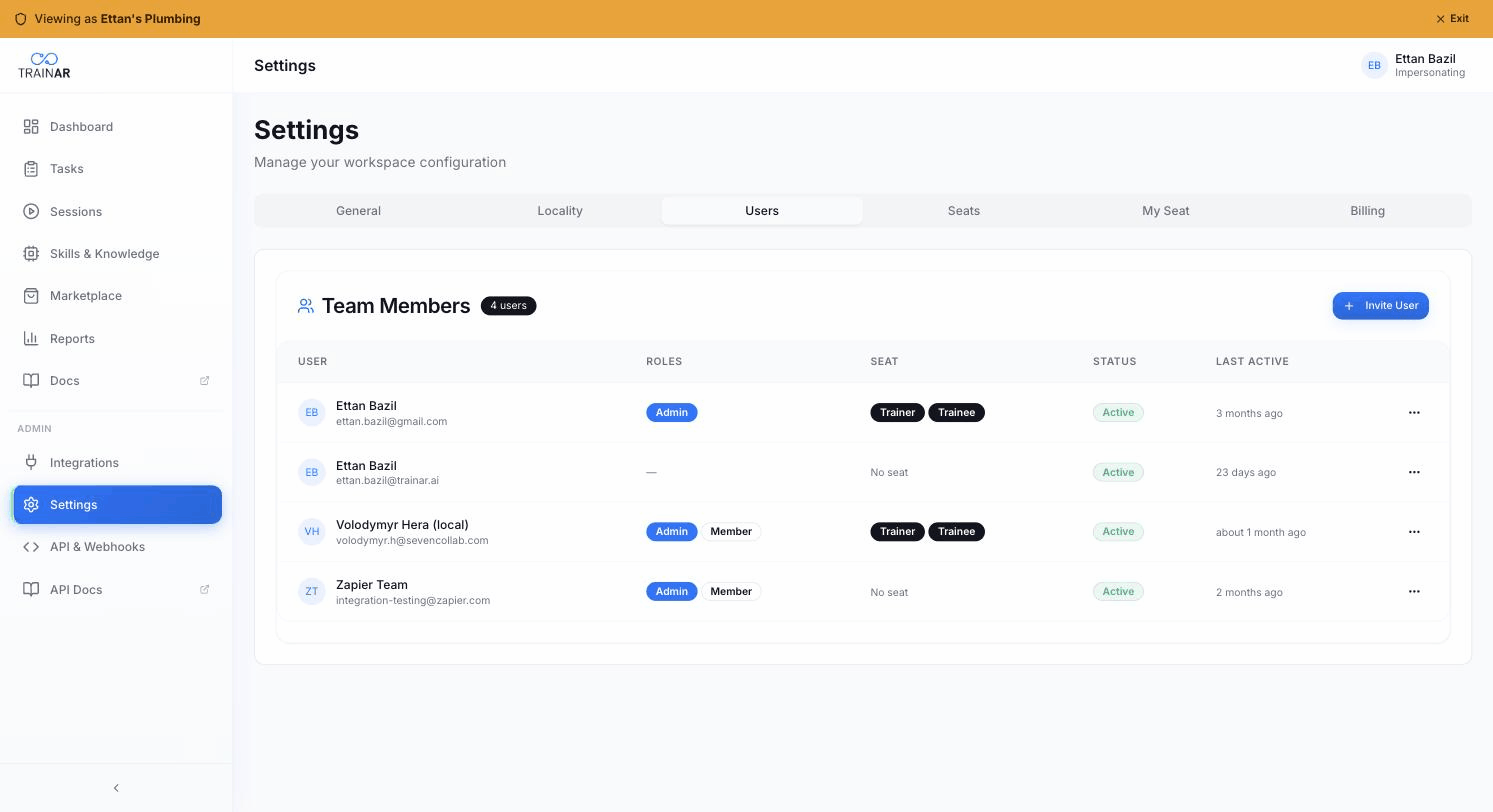 Settings → Users — Team Members table with role + seat + status columns + Invite User button